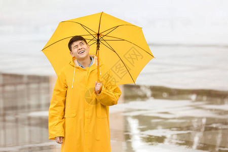 穿雨衣在城市街上带伞的图片