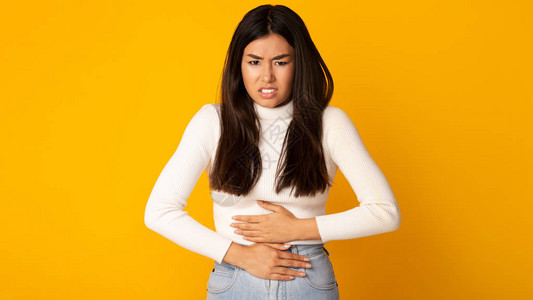 有胃痛的亚洲女孩有食物中毒或月经期抽筋图片