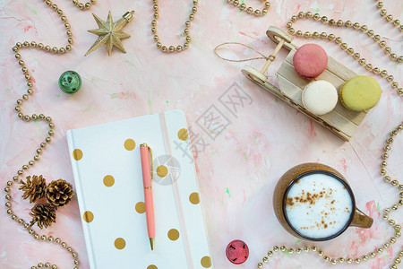 记事本笔咖啡和杏仁饼以及办公桌工作区上的圣诞装饰图片