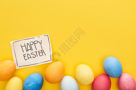 彩蛋和贺卡的顶部视图复活节快乐用黄色背景图片