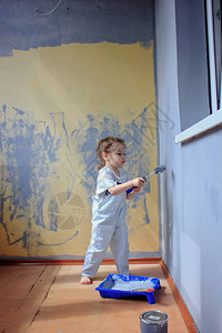 小女孩用油漆滚筒刷墙图片