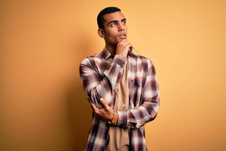 年轻英俊的非洲裔美国人穿着休闲衬衫站在黄色背景上图片