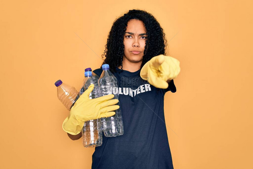 做志愿回收工作的年轻非洲裔美国妇女拿着塑料瓶图片