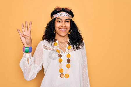 身着太阳镜和古董饰品的年轻非裔美国卷发嬉皮女郎展示并举起第四指头图片