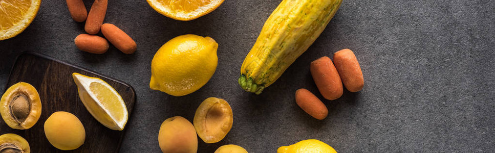 黄水果和蔬菜在木板上以灰色纹质背景全景拍摄的黄图片