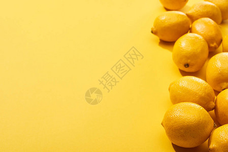 黄色背景上新鲜成熟的整个柠檬图片