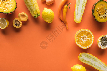 黄水果和蔬菜的顶部视图橙色背景图片