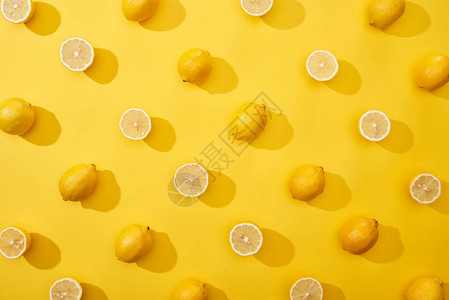 黄底的全柠檬和成熟切背景图片