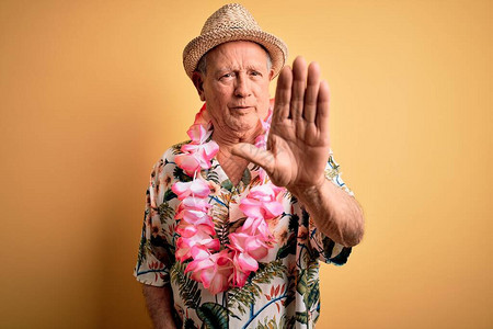 穿着夏帽的灰色长发老人和身穿黄色背景的hawaiian图片