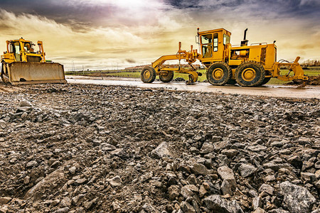 挖掘机在道路建设中平整和平整土地背景图片