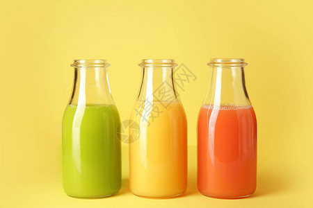 瓶在颜色背景的新鲜果汁图片