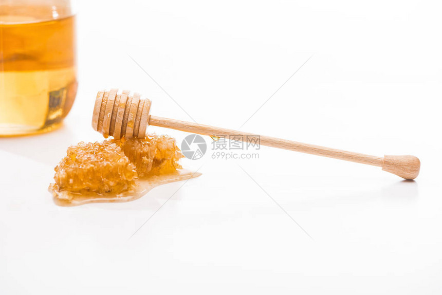甜蜂蜜和木制蜂蜜在白色孤图片