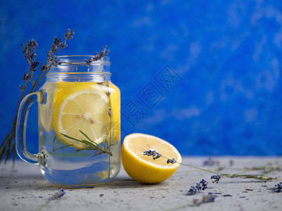 蓝色背景的罐子里加柠檬的薰衣草水图片