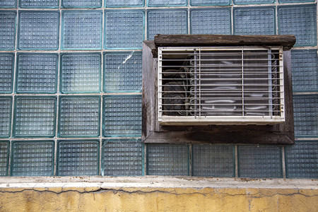 玻璃砖墙上的破旧空调图片