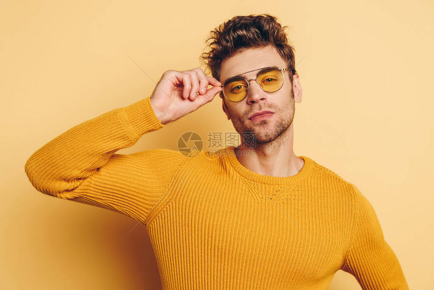 英俊自信的男人一边摸着眼镜一边看着黄图片
