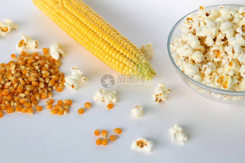 碗里的爆米花还有黄色玉米粒和鳕鱼玉米在白色背景最顶图片
