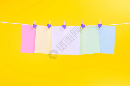 黄色背景上挂着绳索的彩色纸牌背景图片