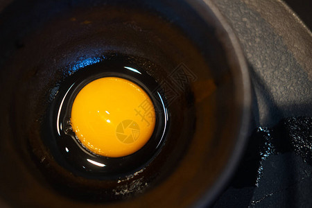 黑碗中的特写生鸡蛋烹饪原料图片