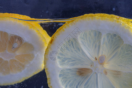 两片柠檬与种子在水中的特写图片