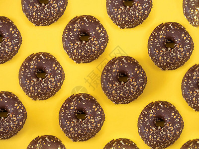 黄色背景杏仁图案的巧克力甜圈图片