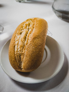 白桌上白圆盘上的面包卷图片