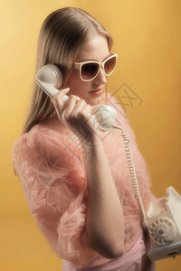 20世纪的夏日时装女郎穿着粉红色毛衣和墨镜用白图片