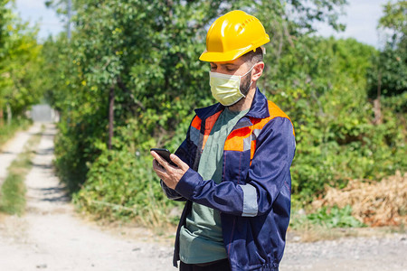 戴黄色头盔和医用口罩的建筑工人工作图片