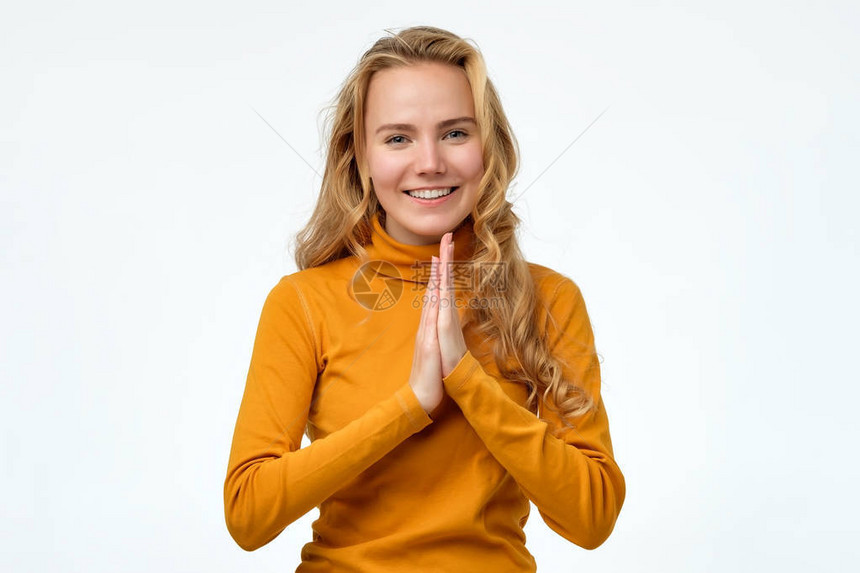 年轻的欧洲女人让悲哀的双眼牵手一起祈祷Namaste签图片