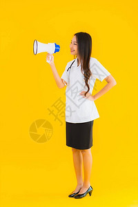 女在黄色孤立背景使用扩音器的年轻医生图片