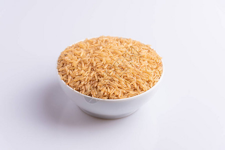 白色背景的白色碗中生糙米的角度视图图片