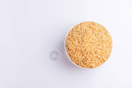 白色背景的白色碗中生糙米的顶部视图图片