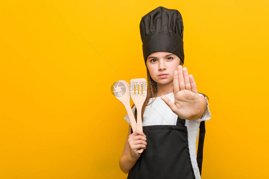 小caucasian女孩穿着厨师服装站着伸展的手显示停图片