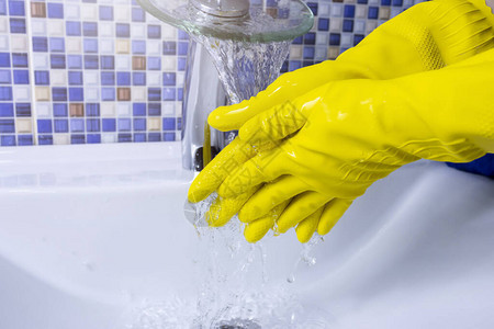 穿黄色橡皮手套的妇女用紧身衣洗手清图片