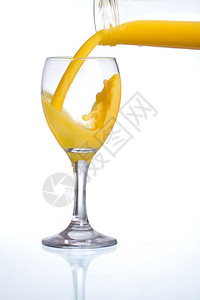 将新鲜橙汁倒入玻璃杯中带反射图片