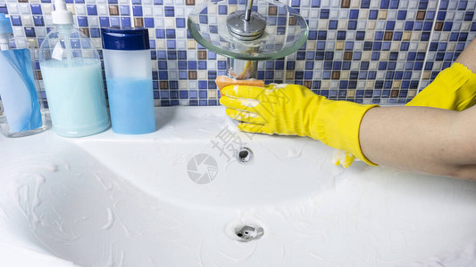 戴保护黄色橡皮手套的妇女用洗涤图片