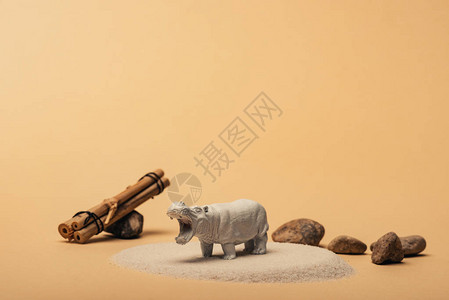 白色的玩具河马黄底带石头和木棍动物福图片