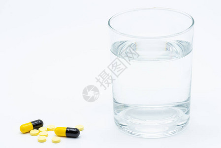 一杯水和白色背景上的药丸背景图片