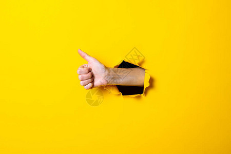 男手举起拇指的手势一切都没事在黄背景图片
