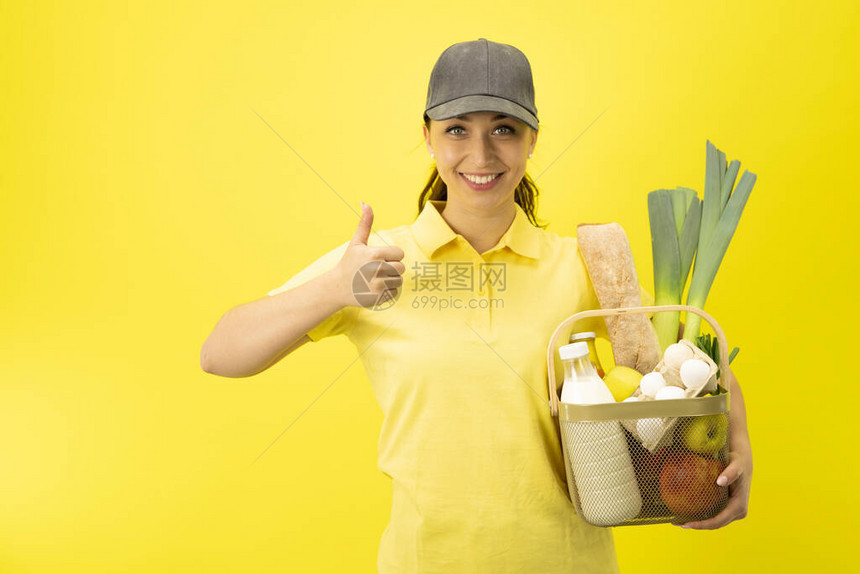 黄色背景复制空间手势上带着杂货篮的微笑送餐服务女孩图片