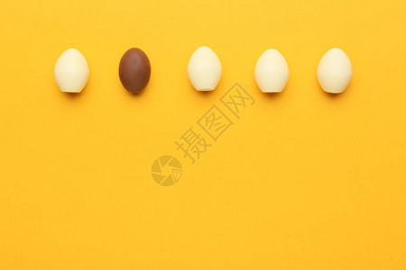 颜色背景白蛋中的棕色巧克力复活节鸡蛋图片