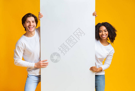 快乐的异族夫妇拿着大白广告板图片