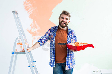 男用油漆滚筒粉刷墙壁一个有趣的家伙在她的新公寓里画墙的肖像重新装修图片
