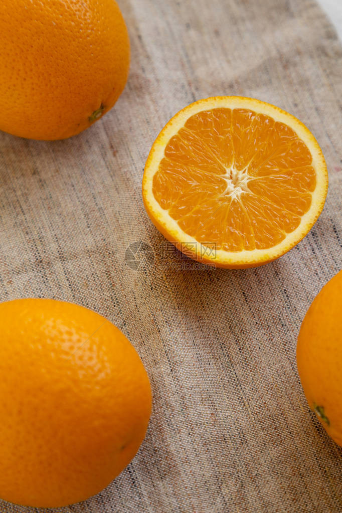 鲜熟的有机橙子在布上图片