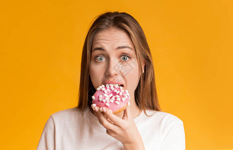 女孩食用甜圈偏爱不健康的食品以脸面表白横扫黄图片