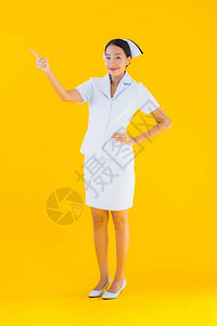 在诊所和医院以黄色孤立背景为病人做许多手术的年轻亚洲泰籍护士图片