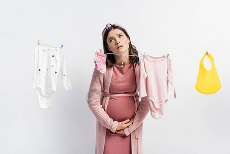 孕妇在衣着线上接近婴儿衣服的腹部时图片