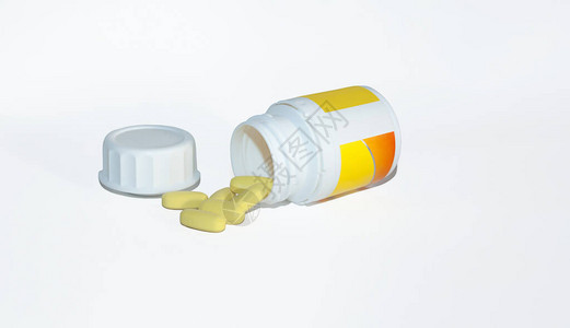 片剂形式的黄色维生素从一个白色罐子里掉了出来在白图片