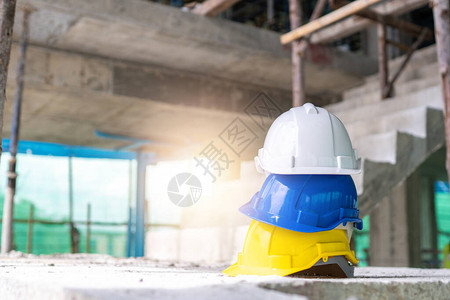 建筑工地建筑工作场所地板安全事故堆的白色黄色和蓝色硬质安全帽领导图片