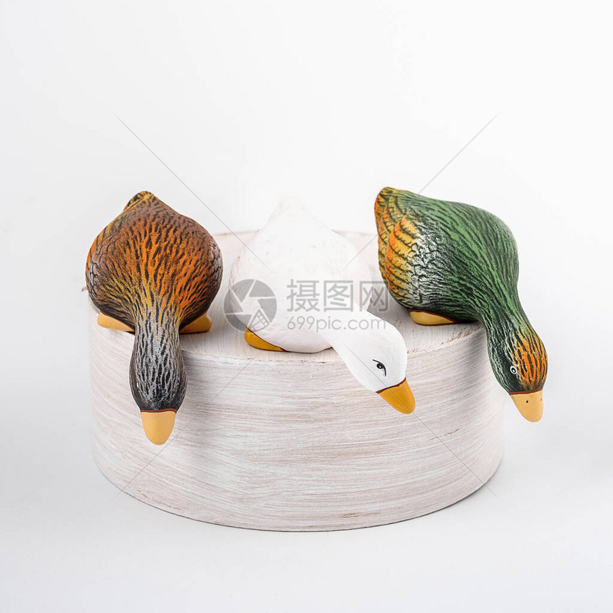 三只陶瓷鸭留在树桩上往下看孤立的彩图片