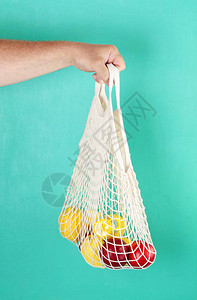 用柠檬水果和玻璃瓶装的可再使用的购物网包图片
